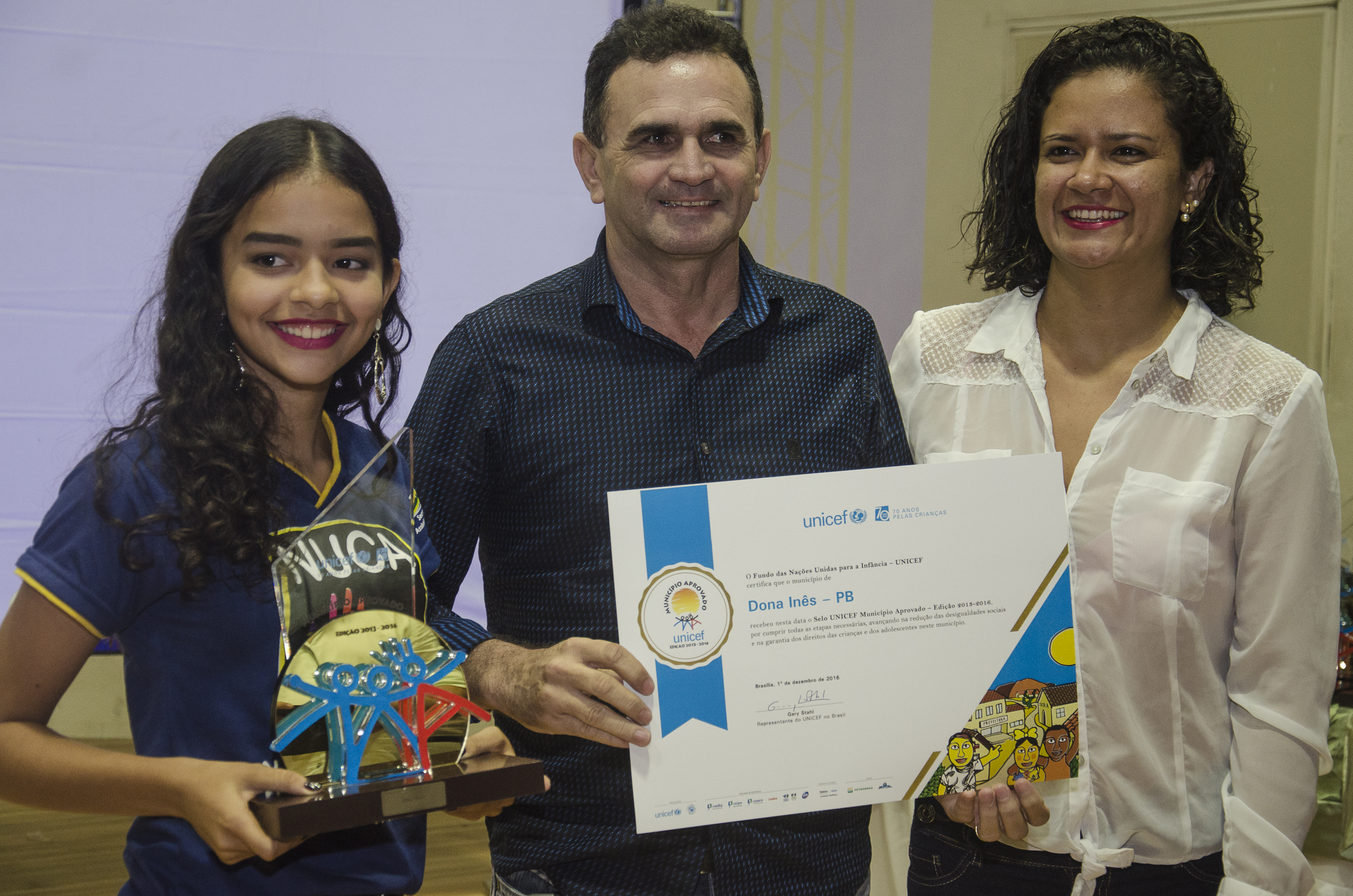 Adolescent from NUCA, the mayor and Seal coordinator from Dona Inês, state of Paraíba, receiving trophy the certificate of UNICEF Municipal Seal of Approval, in Dec, 2016.